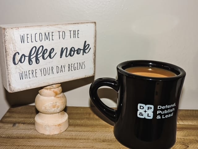 defend, publish & lead coffee mug on a table